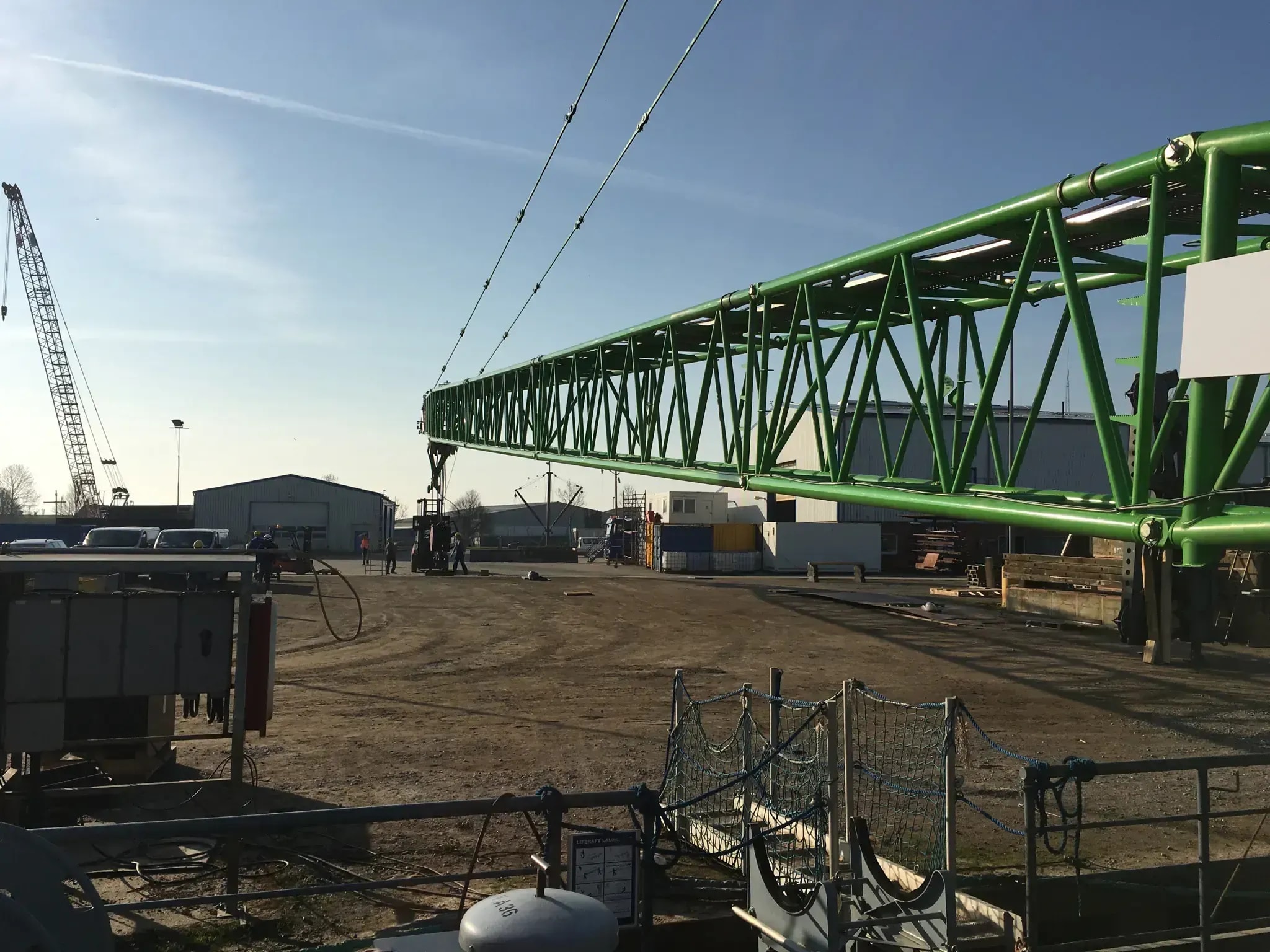 Grüner Kran-Gitterausleger auf Baustelle, bereit zur Kranprüfung durch PISA Nord