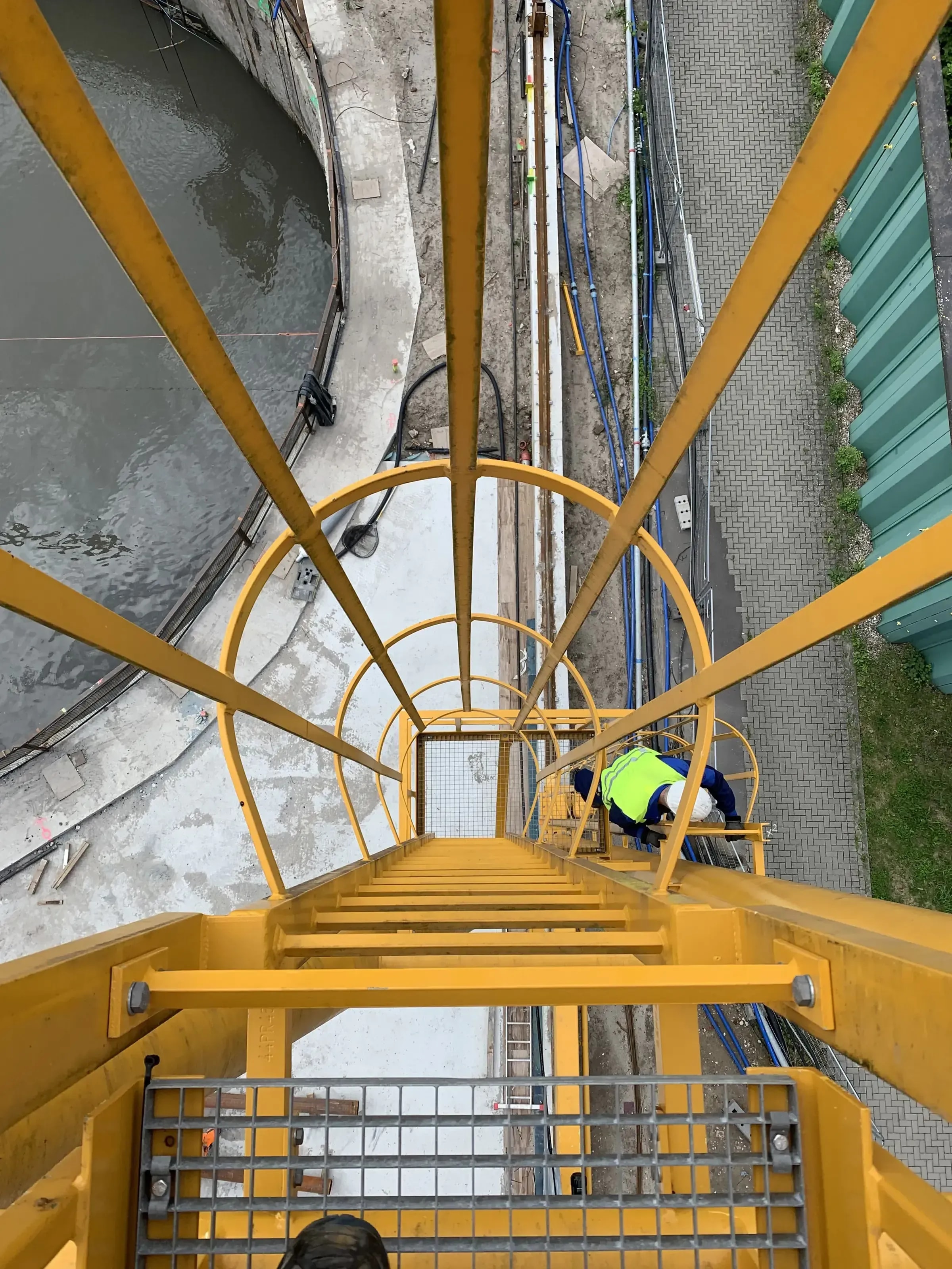 Blick von Kranleiter auf Monteur bei Wartung und Kranpruefung auf der Baustelle
